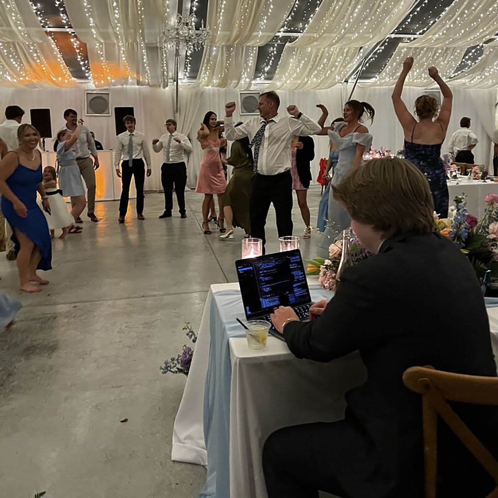 Co-founder Casey working on his laptop at his wedding, known for his reputation as 